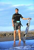 Portrait of a young  kitsurf  man at beach on sunset photo
