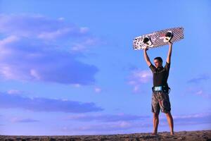 retrato, de, un, joven, kitsurf, hombre, en, playa, en, ocaso foto