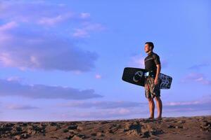 retrato, de, un, joven, kitsurf, hombre, en, playa, en, ocaso foto