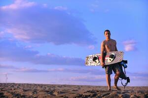 retrato, de, un, joven, kitsurf, hombre, en, playa, en, ocaso foto