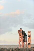 surf couple posing at beach on sunset photo