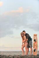 surf couple posing at beach on sunset photo