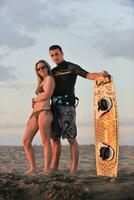 surf couple posing at beach on sunset photo