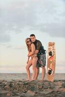 surf couple posing at beach on sunset photo