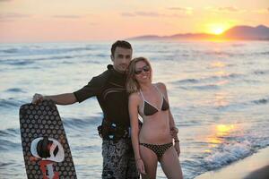 surf couple posing at beach on sunset photo