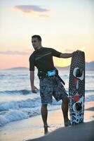 Portrait of a young  kitsurf  man at beach on sunset photo