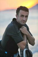 Portrait of a young  kitsurf  man at beach on sunset photo