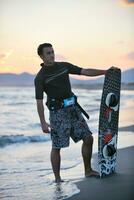 Portrait of a young  kitsurf  man at beach on sunset photo