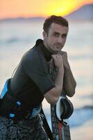 retrato, de, un, joven, kitsurf, hombre, en, playa, en, ocaso foto