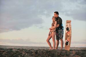 surf couple posing at beach on sunset photo