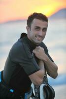 Portrait of a young  kitsurf  man at beach on sunset photo