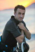 Portrait of a young  kitsurf  man at beach on sunset photo