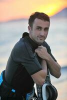 Portrait of a young  kitsurf  man at beach on sunset photo