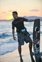 Portrait of a young  kitsurf  man at beach on sunset photo