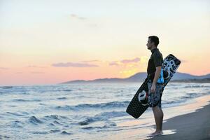 Portrait of a young  kitsurf  man at beach on sunset photo