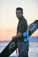 Portrait of a young  kitsurf  man at beach on sunset photo