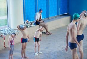 grupo de niños en la clase de la escuela de piscina foto