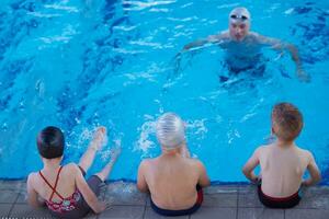 grupo de niños en la clase de la escuela de piscina foto