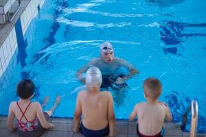 grupo de niños en la clase de la escuela de piscina foto