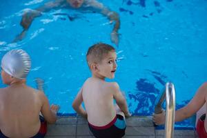 grupo de niños en la clase de la escuela de piscina foto