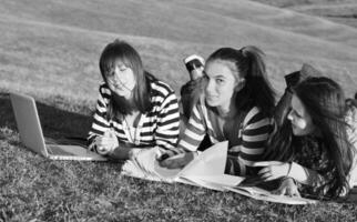 grupo de adolescentes trabajando en una laptop al aire libre foto