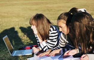 grupo de adolescentes trabajando en una laptop al aire libre foto