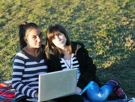 grupo de adolescentes trabajando en una laptop al aire libre foto