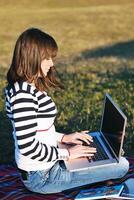 young teen girl work on laptop outdoor photo