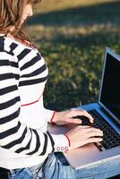 young teen girl work on laptop outdoor photo