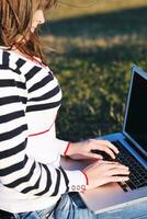 young teen girl work on laptop outdoor photo