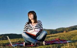 young teen girl work on laptop outdoor photo