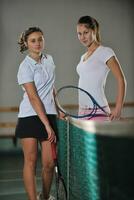 young girls playing tennis game indoor photo