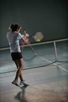 young girls playing tennis game indoor photo