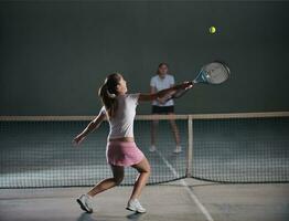 young girls playing tennis game indoor photo