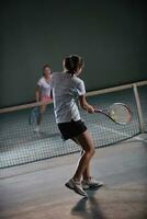 young girls playing tennis game indoor photo