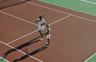 feliz pareja joven jugar al tenis al aire libre foto