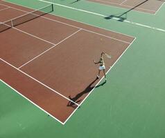 mujer joven jugar al tenis al aire libre foto