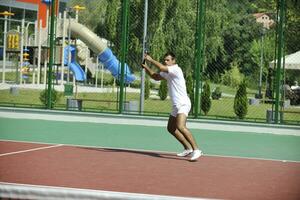 joven jugar al tenis al aire libre foto