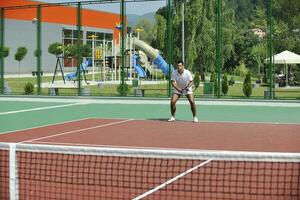 young man play tennis outdoor photo