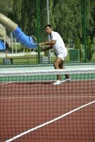 joven jugar al tenis al aire libre foto