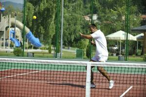 joven jugar al tenis al aire libre foto