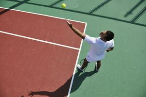 joven jugar al tenis al aire libre foto