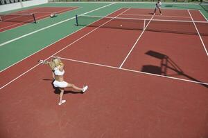 mujer joven jugar juego de tenis al aire libre foto