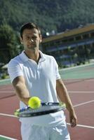 joven jugar al tenis al aire libre foto