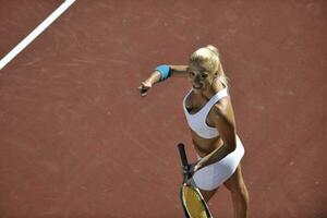 mujer joven jugar al tenis al aire libre foto