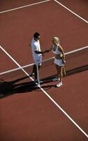 happy young couple play tennis game outdoor photo