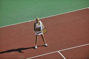 mujer joven jugar al tenis al aire libre foto