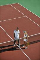 happy young couple play tennis game outdoor photo