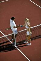 happy young couple play tennis game outdoor photo