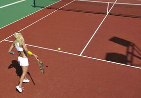 young woman play tennis game outdoor photo